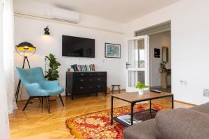 a living room with a couch and a blue chair at Alaburic rooms & apartment in Mali Lošinj