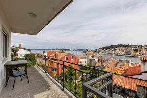 a balcony with a view of the water and buildings at Alaburic rooms & apartment in Mali Lošinj