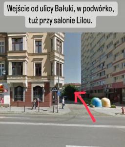 una flecha roja apuntando a un edificio en una calle de la ciudad en Lux Studio en Szczecin