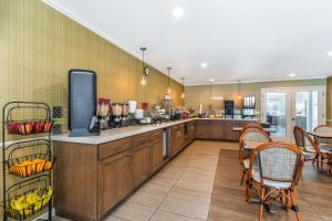 a large kitchen with wooden cabinets and a table and chairs at Best Western Plus Inn Scotts Valley in Scotts Valley