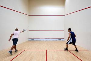 dos hombres jugando al squash en un gimnasio en Radisson Blu Hotel & Spa, Nashik en Nashik