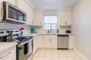 a kitchen with white cabinets and a stove top oven at Modern Apartment - Corktown Hamilton in Hamilton