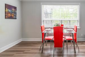a dining room with a table and red chairs at Modern Apartment - Corktown Hamilton in Hamilton +6 photos