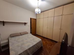 a bedroom with a bed and cabinets and a chair at Casa Vila da Saúde, aconchegante com 2 garagens e 2 quartos in São Paulo