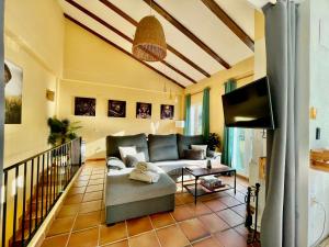 sala de estar con sofá y TV en Casa Rural Una Ventana a la Montaña, en Aracena