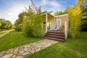 a small house with a deck with chairs on it at Mobile Homes Peškera in Pula