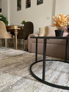 a living room with a couch and a table at شقة فندقية فاخرة لعشاق الهدوء والسكن الراقي في مدينتي in Madinaty