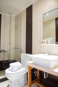 een badkamer met een wastafel, een toilet en een spiegel bij Dalasvillas SkalaMare in Skála Kefalonias