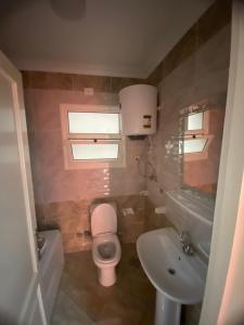 a bathroom with a pink toilet and a sink at شقة فندقية فاخرة لعشاق الهدوء والسكن الراقي في مدينتي in Madinaty