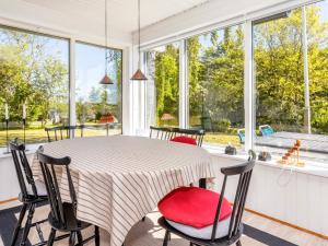 - une salle à manger avec une table, des chaises et des fenêtres dans l'établissement Holiday home Nykøbing M VII, à Alsted
