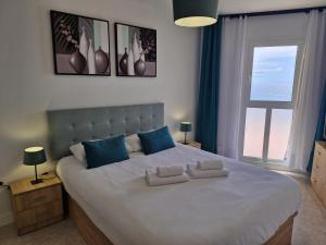 ein Schlafzimmer mit einem großen Bett mit zwei Kissen darauf in der Unterkunft Beach View Las Americas in Playa de las Americas