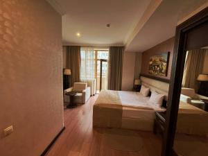 Habitación de hotel con cama y silla en Smith Hotel Baku en Bakú