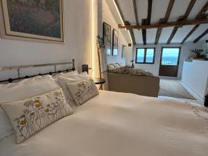 Un dormitorio con una cama con sábanas y almohadas blancas. en Casa Árbol, en Pedro Bernardo 37 fotos más