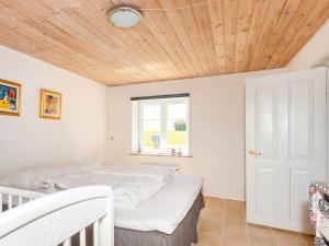 a bedroom with a bed and a wooden ceiling at 5 person holiday home in Karby-By Traum in Karby