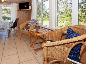 a living room with wicker chairs and a table at Holiday home Thisted XXI in Sønder Vorupør