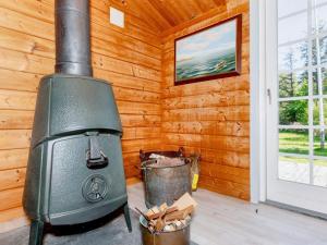 een kachel in een houten kamer met twee emmers bij Holiday home Roslev XXXIII in Roslev
