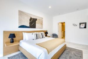 a bedroom with a large white bed and a painting at Marea Los Cabos Albatros 202 in Cabo San Lucas +28 photos
