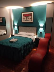 sypialnia z łóżkiem i czerwonym krzesłem w obiekcie Hostal El Pilar w mieście Lima