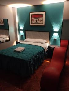 - une chambre avec un lit et une chaise rouge dans l'établissement Hostal El Pilar, à Lima