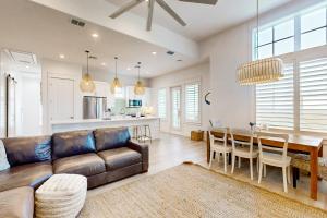 a living room with a brown leather couch and a table at Mimosa Manor in Port Aransas
