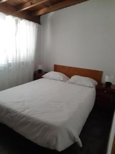 1 dormitorio con cama blanca y ventana en Casas de Marvão - Quinta da Bela Vista en Marvão