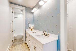 a bathroom with a white sink and a blue wall at Mimosa Manor in Port Aransas +33 photos