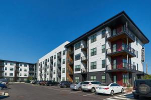 a parking lot with cars parked in front of a building at Rare 1BDR Apt with Pool Gym Parking in Indianapolis