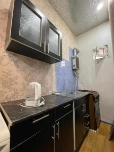トビリシにあるGuest house Odzisiのシンクと電子レンジ付きのキッチン