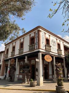 un edificio con dos estatuas delante en Hotel El Aguila, en Villa del Carbón
