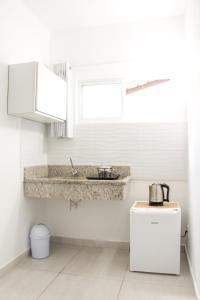 uma cozinha com um lavatório e um balcão em Canto das Ondas Apart Studios em São Francisco do Sul