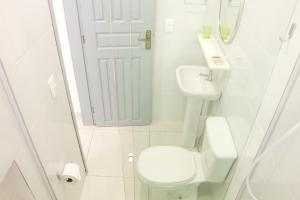 uma casa de banho branca com um WC e um lavatório em Canto das Ondas Apart Studios em São Francisco do Sul