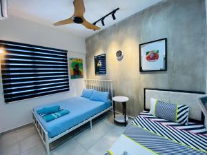 sypialnia z niebieskim łóżkiem i oknem w obiekcie Orang Utan Guest House w mieście Sandakan