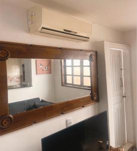 a mirror in a living room with a tv at Praiana do Luquinhas - Macumba / Pontal / RicoSurf in Rio de Janeiro