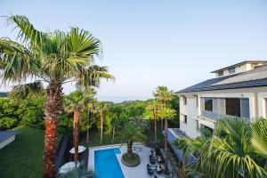 an aerial view of a house with a swimming pool and palm trees at Shonan OVA in Yokosuka