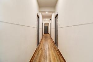 un largo pasillo con paredes blancas y suelos de madera en Townhouse XOTEL, en Bangalore