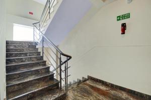 un escalier dans un bâtiment avec un panneau sur le mur dans l'établissement Townhouse XOTEL, à Bangalore