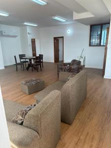 a living room with two couches and a table and chairs at Alice's Abode in Port-of-Spain