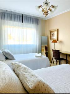 a hotel room with two beds and a window at Betalia in Caldas de Reis