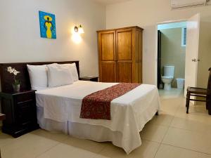 a bedroom with a large bed and a toilet at Casa Amalia in Willemstad