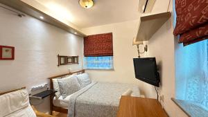 a small room with a bed and a tv at Bali Holiday Resort in Hong Kong