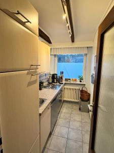 a kitchen with a refrigerator and a sink and a window at Ostseewiesen-2 in Hohwacht