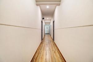 Długa drewniana podłoga w pokoju z białymi ścianami w obiekcie Townhouse XOTEL w mieście Bengaluru