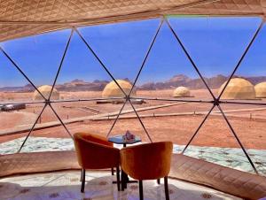 um quarto com vista para o deserto a partir de uma janela em Katrina Rum camp em Wadi Rum
