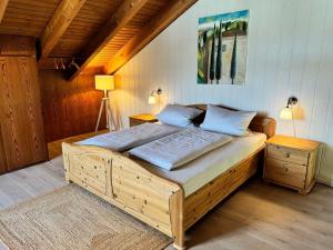a bedroom with a large wooden bed with two pillows at Ostseewiesen-1 in Hohwacht