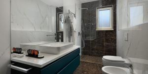Baño blanco con lavabo y aseo en Arté Boutique Hotel, en Tirana