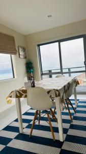 a dining room with a white table and chairs at Sea views from sunny house in Wellington