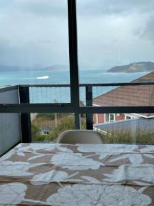 a balcony with a table and a view of the ocean at Sea views from sunny house in Wellington