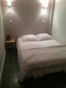 uma cama num quarto com duas luzes na parede em La Cucumelle em La Salle Les Alpes