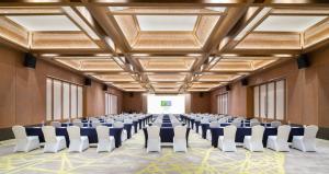 a large room with rows of chairs and a projection screen at Holiday Inn Resort Sanya Bay by IHG in Sanya +180 photos