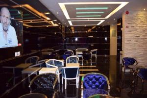 a room with chairs and tables and a screen at نخلة الصحراء للشقق المخدومة in Al Nairyah